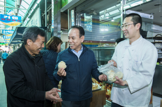 정창길 한국중부발전 사장(앞줄 가운데)이 보령 중앙시장에 있는 빵집에서 빵을 구매하고 있는 모습. 한국중부발전 제공